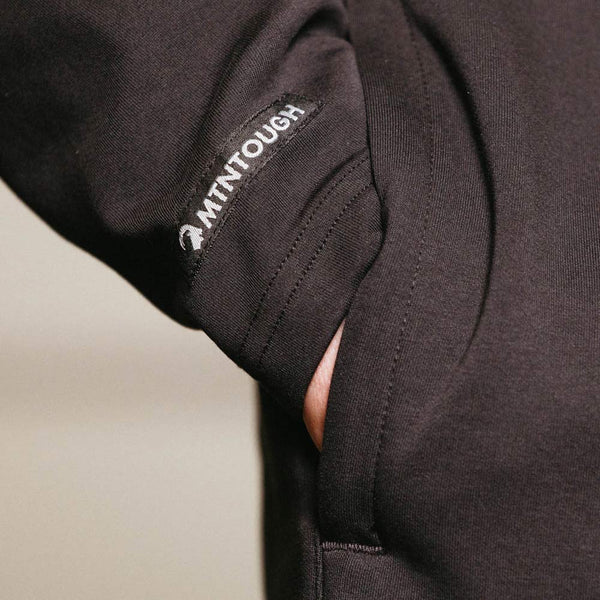 Close-up of a black jacket with a visible brand logo on the sleeve.