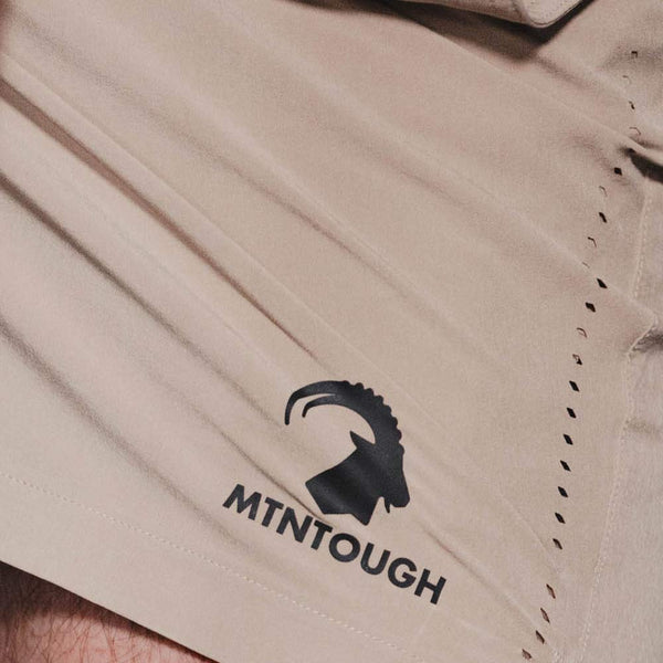 Beige shorts with a black logo and text on a close-up view